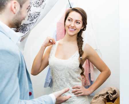 Positive beauty spouses standing at boutique changing cubicleの写真素材