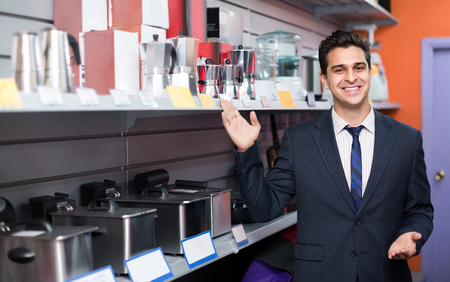Joyful male consultant working at small household appliances section and smilingの写真素材