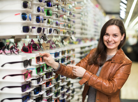 female customer buying sunglasses in optical boutiqueの写真素材