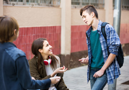 Group of smiling teenage friends chatting and having fun outdoorの写真素材