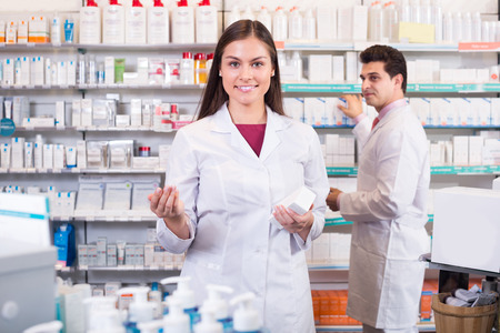 Smiling pharmacist and pharmacy technician posing in drugshopの写真素材