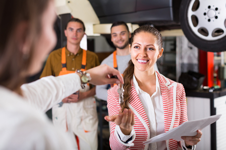 Auto service crew finished work for smiling client at auto serviceの写真素材