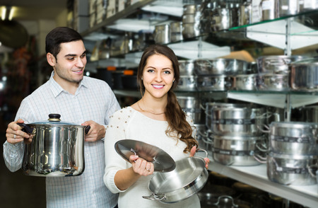Young european couple chooses pans in shop cookwareの写真素材