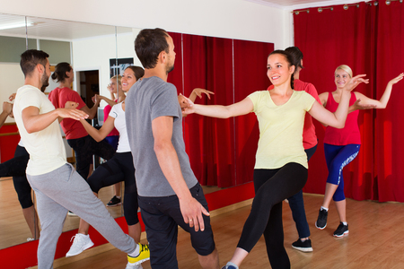 Group of cheerful adults dancing active dance in class. Selective focusの写真素材