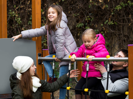 Cheerful young family of four at children's playground