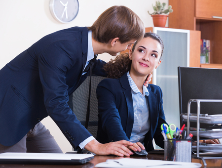 Sexual harassment in office: manager caressing employee and smilingの写真素材