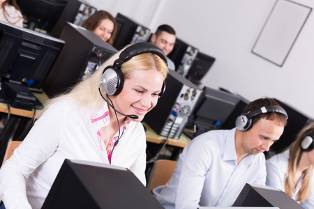 Working process of successful call center team at office and operators. Focus on the blond womanの写真素材