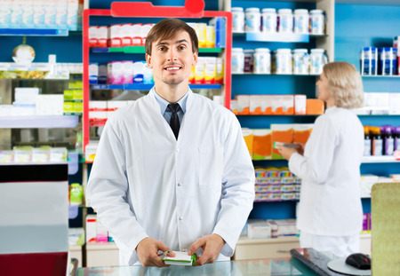 Portrait of two friendly charming pharmacists working in modern farmacyの写真素材