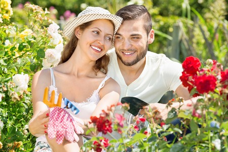 Happy smiling family working in the flowering gardenの写真素材