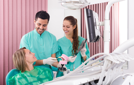 Portrait of doctor and american smiling patient at dental clinicの写真素材