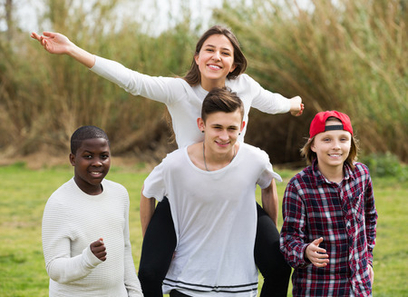 Positive four friends on countryside field in sunny dayの写真素材