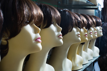 Mannequins with brunet style wigs on shelves of hair salonの写真素材