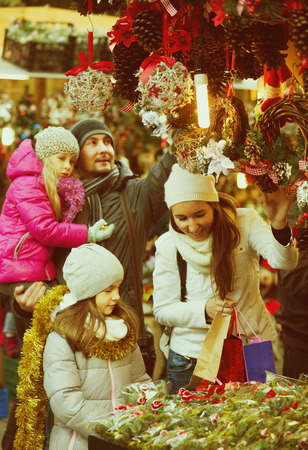 Happy family choosing decorations at market together. Focus on girlの写真素材