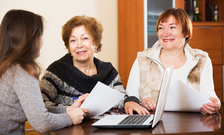 Portrait of happy mature women with papers and agency employeeの写真素材