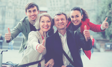 Close up of smiling tourists posing on European city streetの写真素材