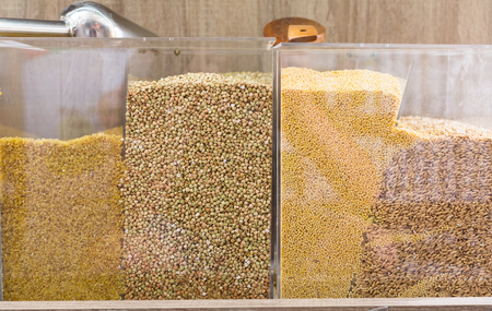 Closeup view on green buckwheat, bulgur and millet in plastic containers in food storeの写真素材