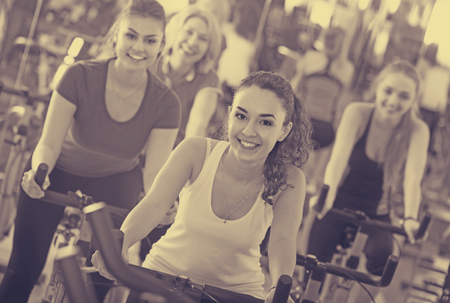 Brunette smiling girl and other females working out in sport clubの写真素材