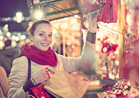 Portrait of female customer near counter at Christmas fair in eveningの写真素材