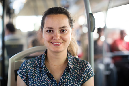 ?adult female passenger taking bus journey in cityの写真素材