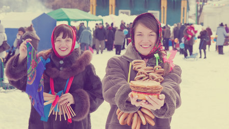 Two happy girls celebrating  Shrovetide  at Russiaの写真素材