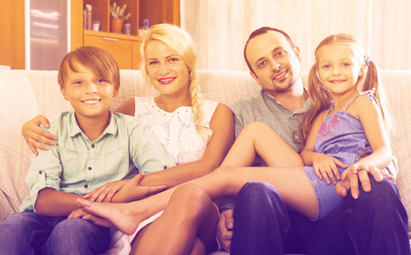 Portrait of happy middle class caucasian family at home interior. Focus on boyの写真素材