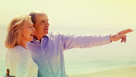 International family in years at seashore vacation pointing fingers and smiling
