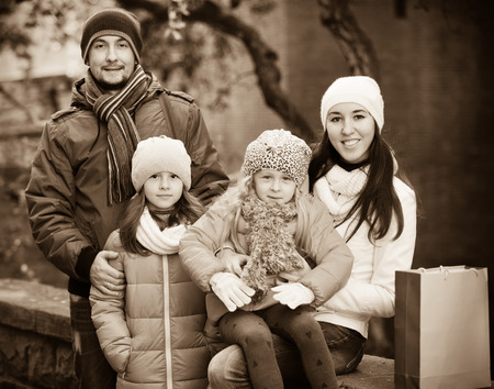 Winter portrait of happy smiling adults with little daughters. Focus on girlの写真素材