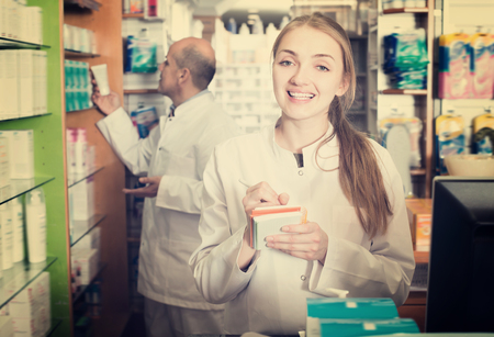 Young pharmacist and pharmacy technician helping in drugstoreの写真素材