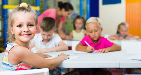 Portrait of cheerful pupil girl studying in school classの写真素材