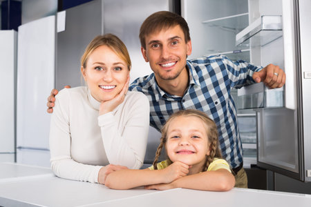 Cheerful family with child together in store with electronicsの写真素材