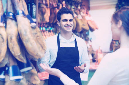 Young american brunette choosing iberico and serrano jamon and smilingの写真素材