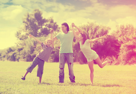 Happy family  with teenage boy enjoying time in summer parkの写真素材