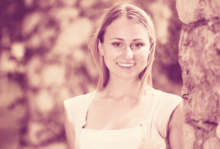 Closeup portrait of attractive young blond woman in garden on summer dayの写真素材