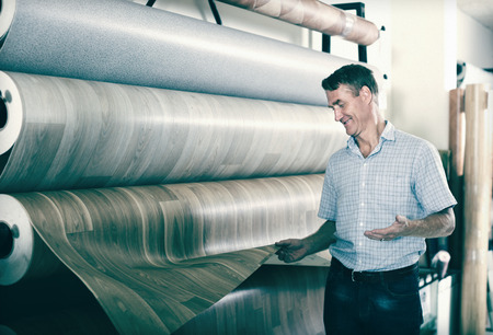 ?man customer choosing bolt of linoleum in interior storeの写真素材