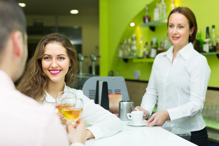 Young couple having a date with wine at bar. Focus on girlの写真素材