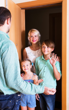 Smiling family coming at threshold with visit to friend. Focus on boyの写真素材