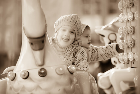 Portrait of little sisters laughing at roundaboutの写真素材