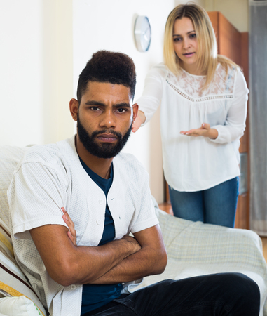 Upset black man and frustrated white housewife having bad quarrelの写真素材