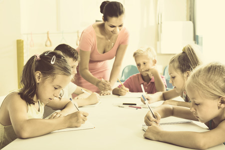 Glad diligent kids learning to write on lesson in elementary school classの写真素材