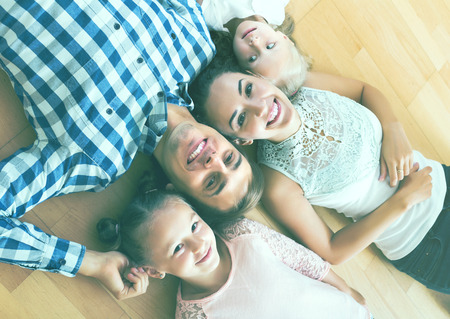 Portrait of happy relaxed family of four posing in domestic interiorの写真素材