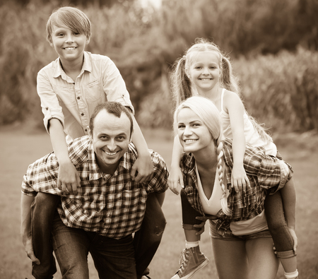 Cheerful active family of four spending summer day at countrysideの写真素材