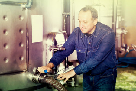 Elderly worker checks equipment on a winery
