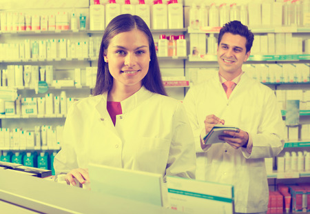 positive pharmacist and pharmacy technician posing in drugstoreの写真素材