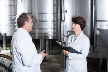 Ordinary wine maker shows to expert equipment on wineryの写真素材