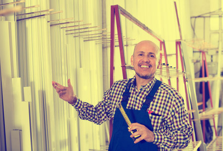 Male middle age worker working in PVC shop and smilingの写真素材