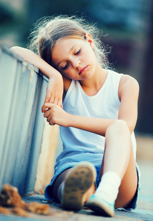 portrait of sad girl being alone and worried outdoorsの写真素材