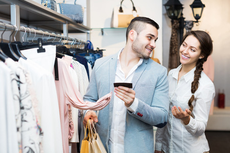 Young spouses smiling while shopping at boutiqueの写真素材