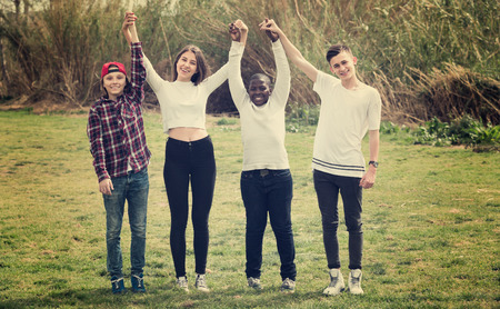 Positive girls and boys posing in spring park and smilingの写真素材