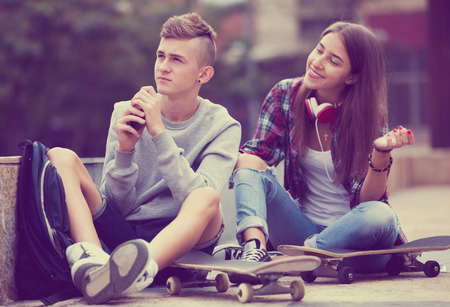 Girl apologizes to her boyfriend after an argument outdoor. Focus on the boyの写真素材