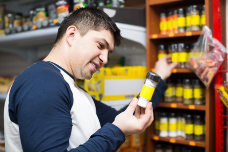 Ordinary american middle age guy purchasing spices at supermarketの写真素材